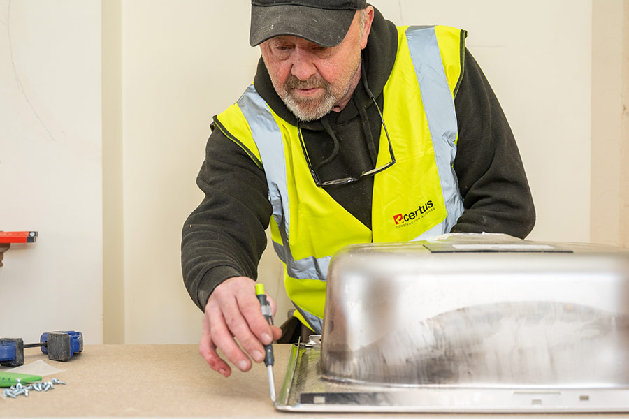 Construction worker fitting a kitchen sink